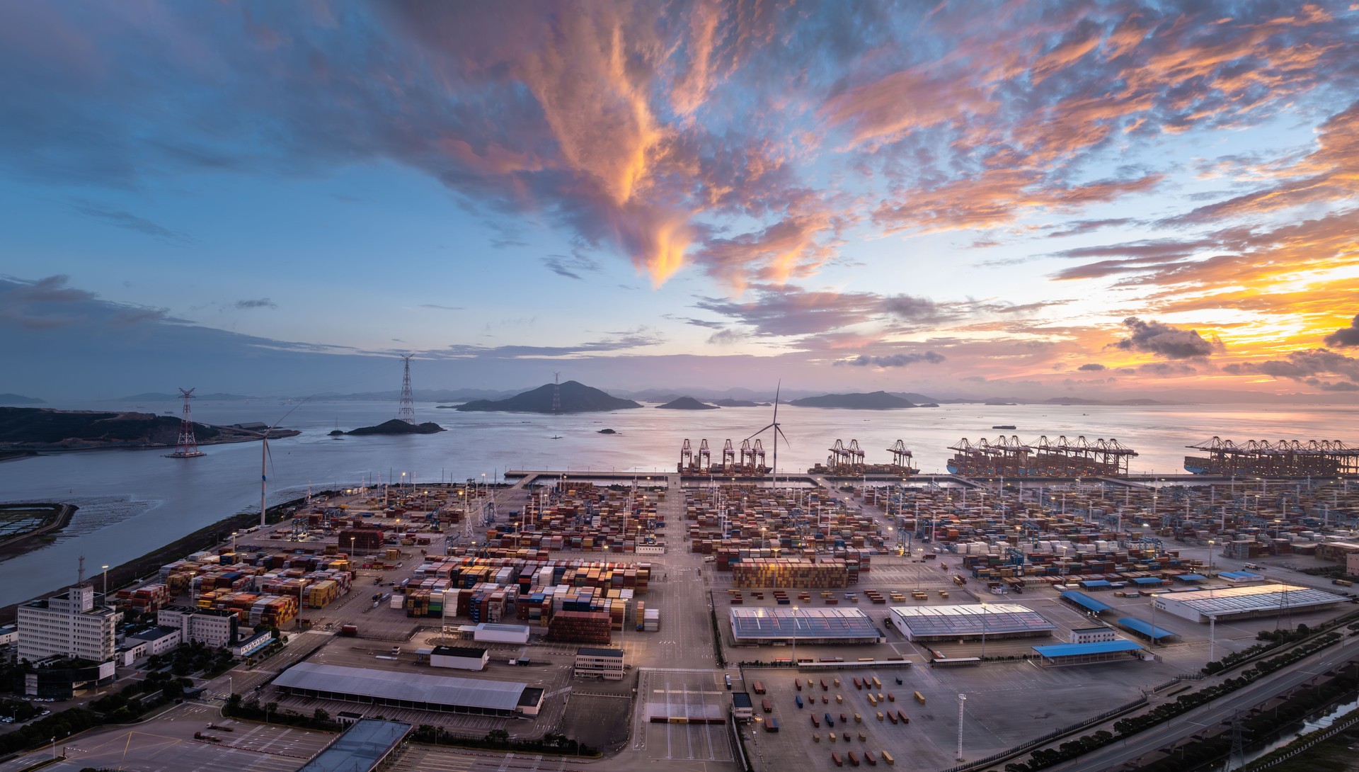 Aerial view of container port and seaside natural scenery at sunrise